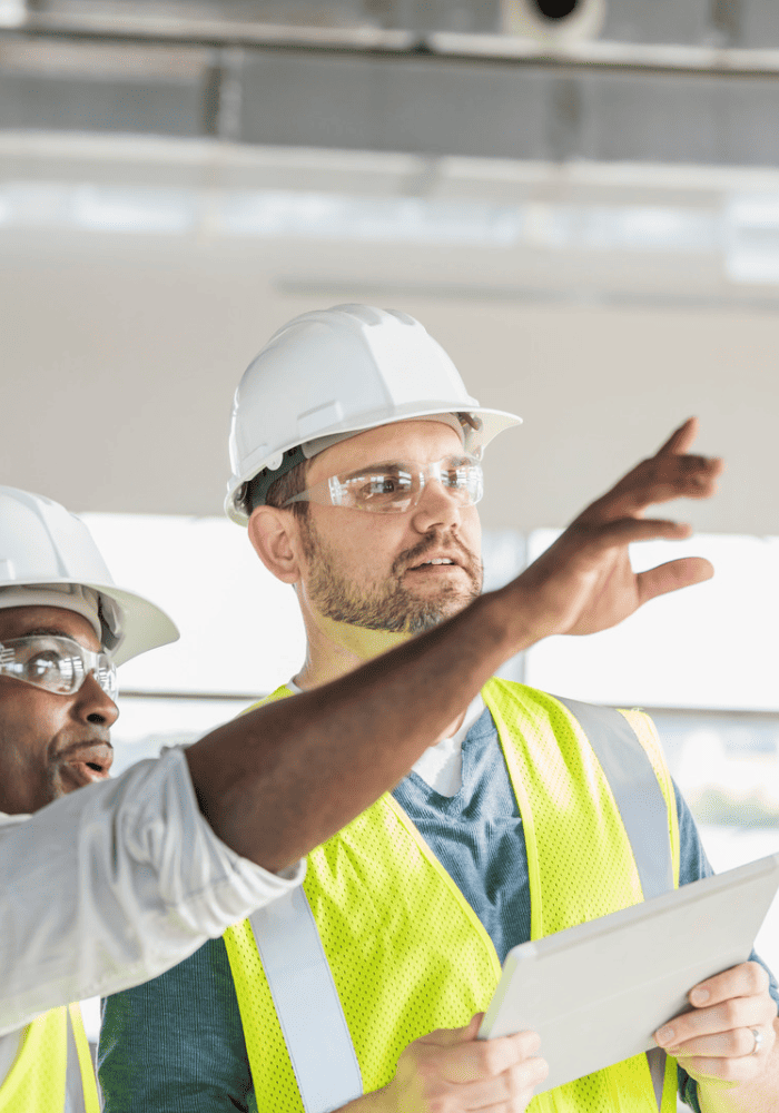 Construction workers capturing health and safety records on tablet